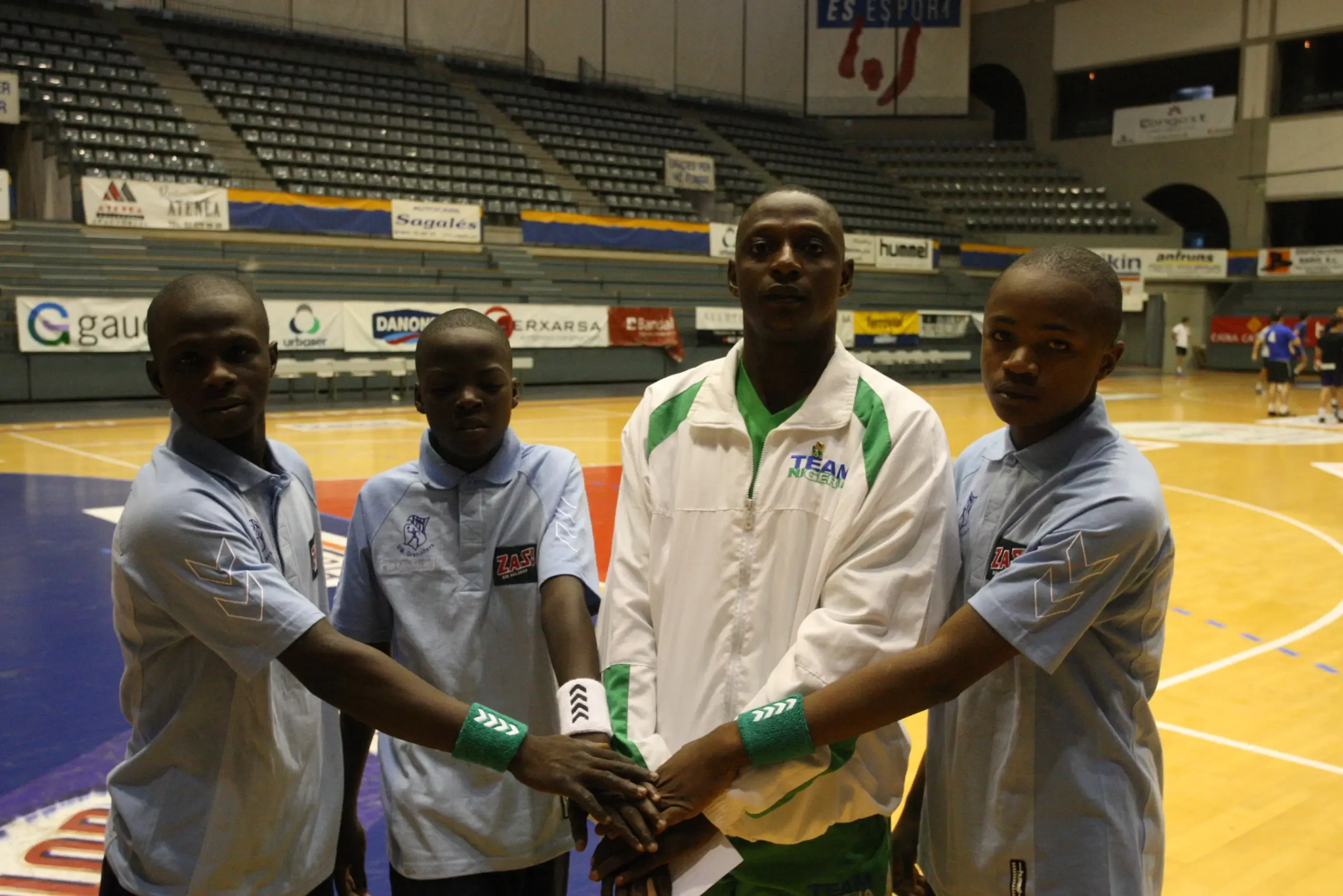 Els tres joves jugadoes, A. Babangida , Alí Hamed i Salisu Garba amb el representant de la Federació de Nigèria d’Handbol al Palau d’Esports.